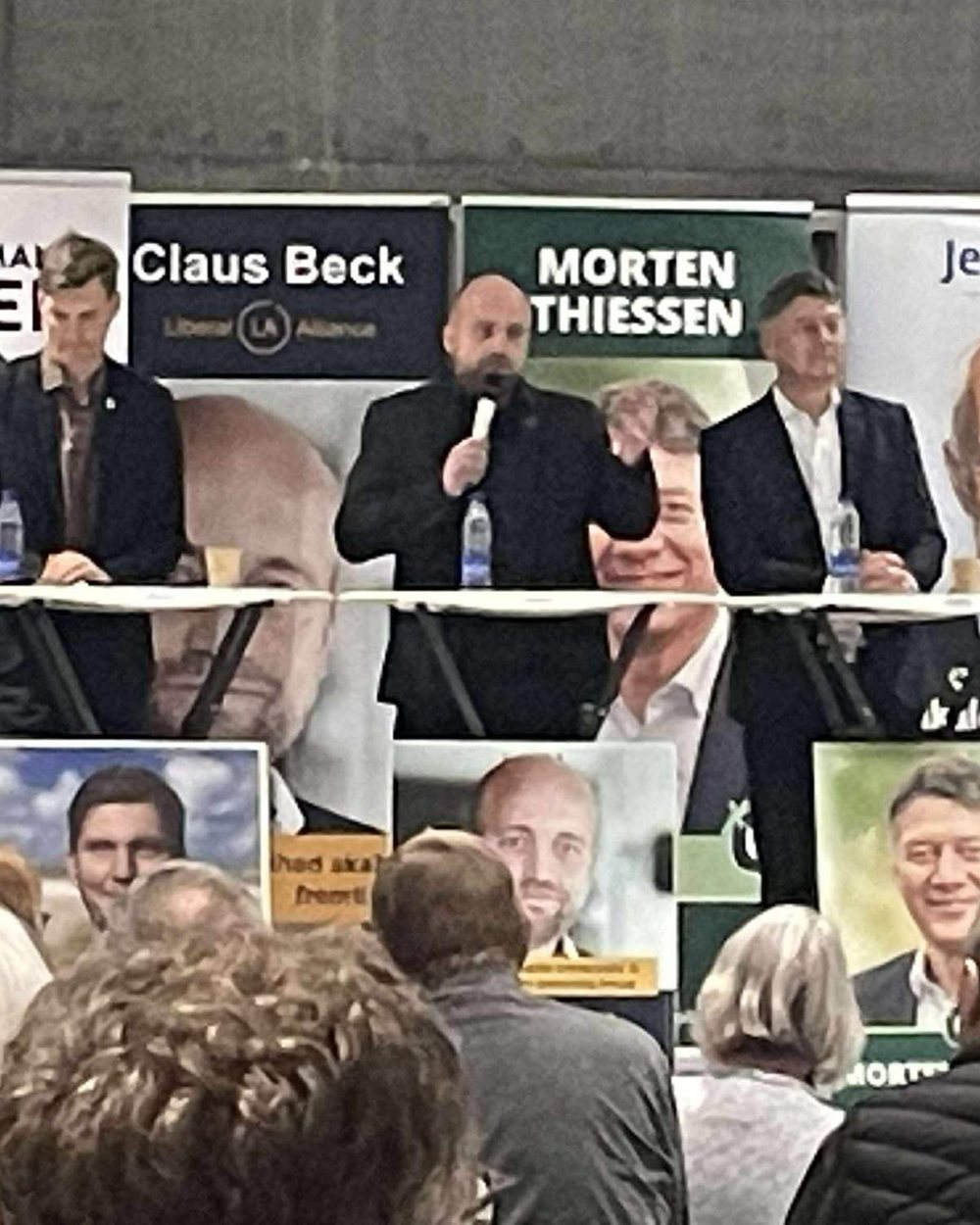 Claus taler med mikrofon ved en vælgerdebat